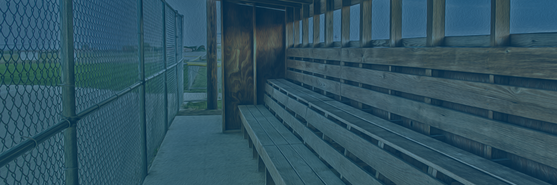 Picture of empty benches inside a baseball or softball dugout