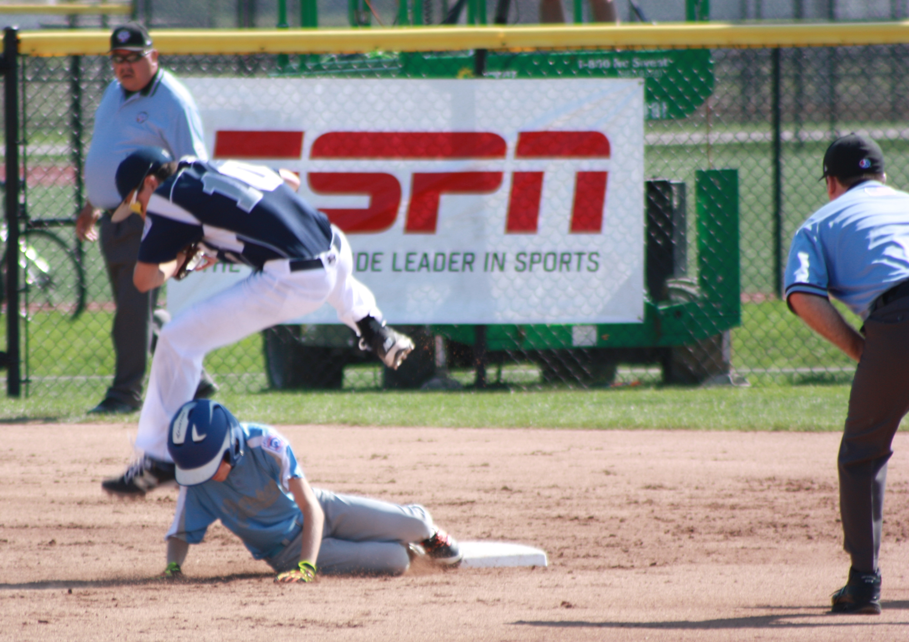 Baseball player sliding and referees