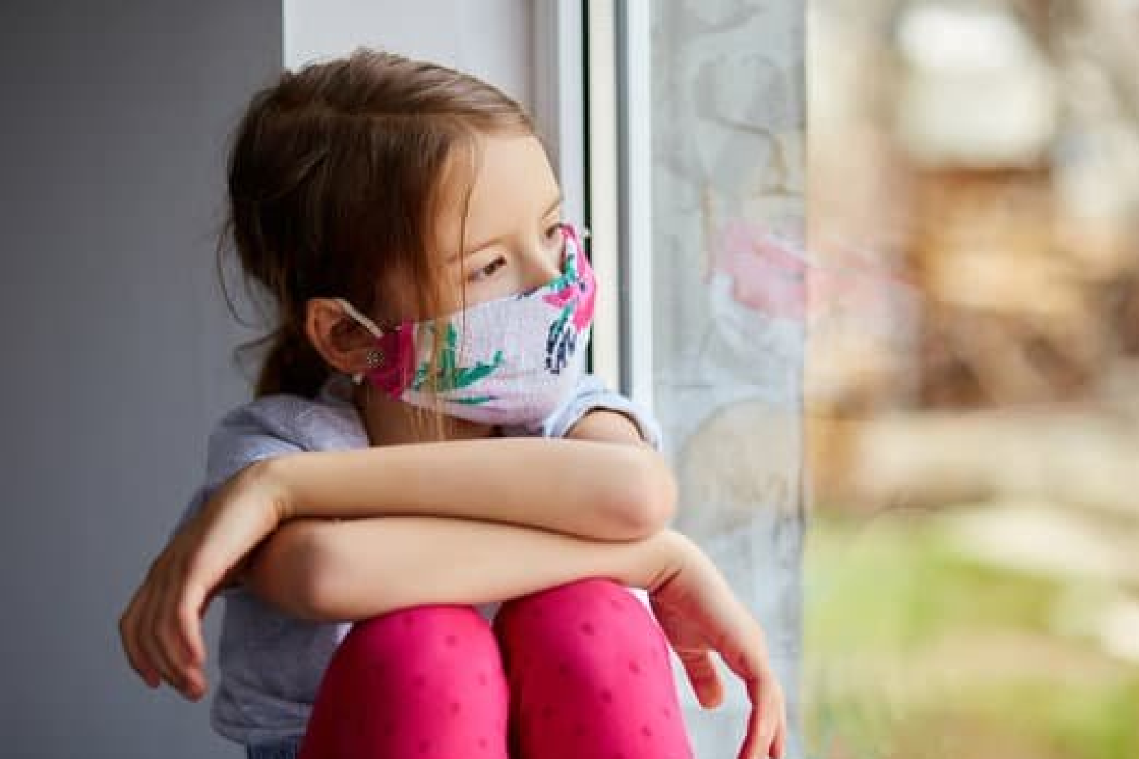 Little girl outdoors wearing a facemask